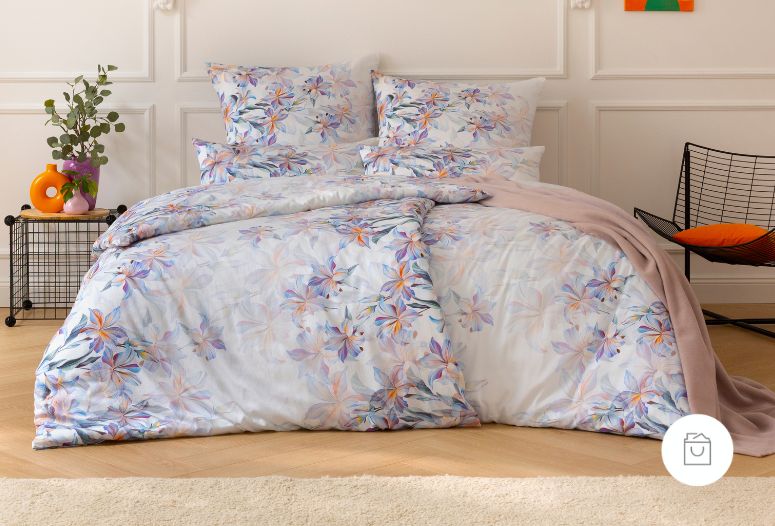 Satin de Luxe Bettwäsche mit farbenfrohem Blumenmuster in Lila-, Orange- und Rosatönen auf leicht glänzendem Stoff.