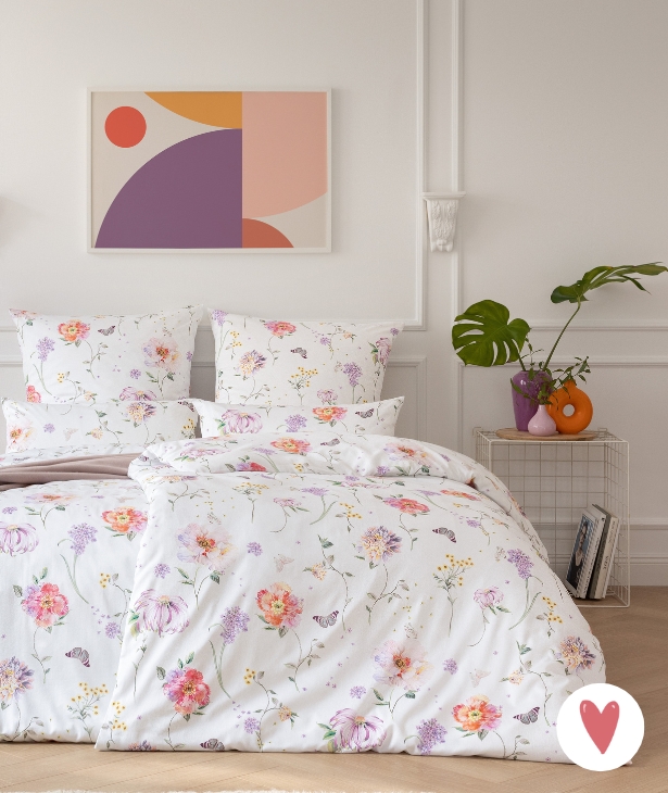 Bettwäsche Aluna mit Blumenmuster in mehreren Farben auf hellem Grund auf Bett im Schlafzimmer