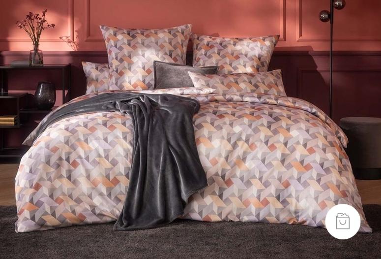 Satin de Luxe-Bettwäsche mit grafischem 3D-Muster in der Farbe Apricot (warmer Orangeton), stilvoll arrangiert. 