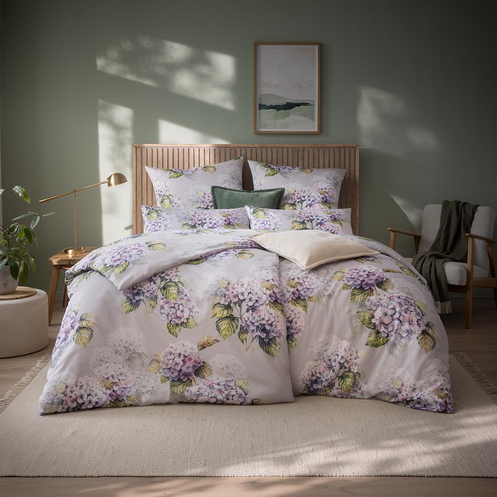  Bettwäsche Rosabella mit floralem Muster in Lila und Grün auf grauem Grund auf Bett im Schlafzimmer