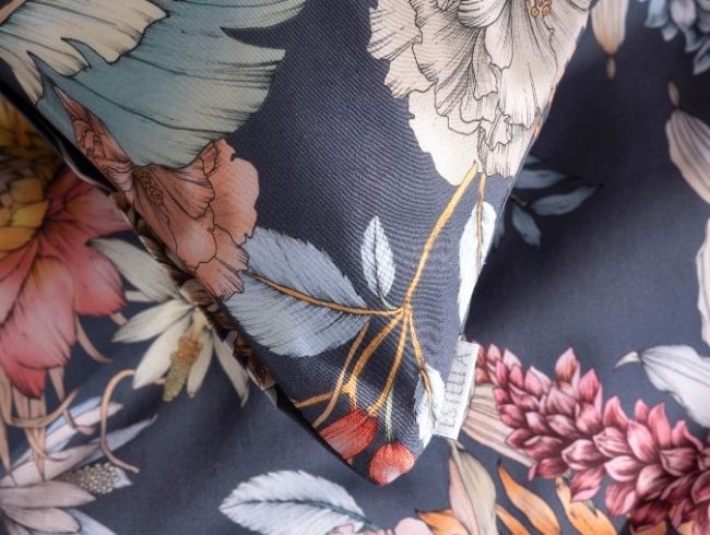 Bettwäsche Claudia mit floralem Muster auf blauem Hintergrund, Detailaufnahme des Stoffes.