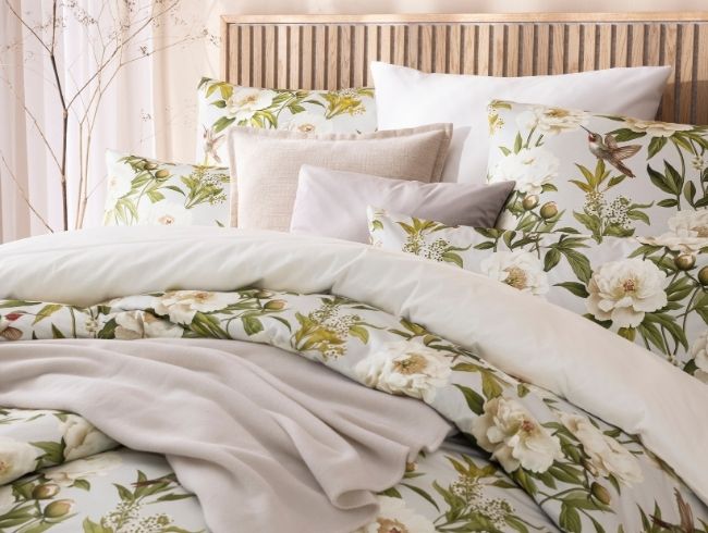 Florale Bettwäsche Yvonne mit weißen Blüten und Vogelmotiv, kombiniert mit unifarbener Bettwäsche Valetta, Dekokissen und Wohndecke auf Doppelbett in hellem Schlafzimmer