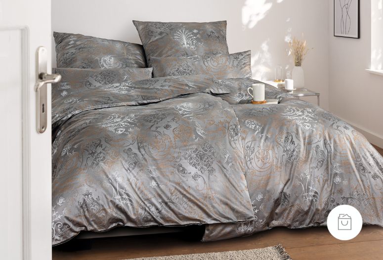 Bettwäsche aus Schweizer Premium Satin mit elegantem Ornamentmuster in Silber- und Bronzetönen auf schimmerndem Grau.
