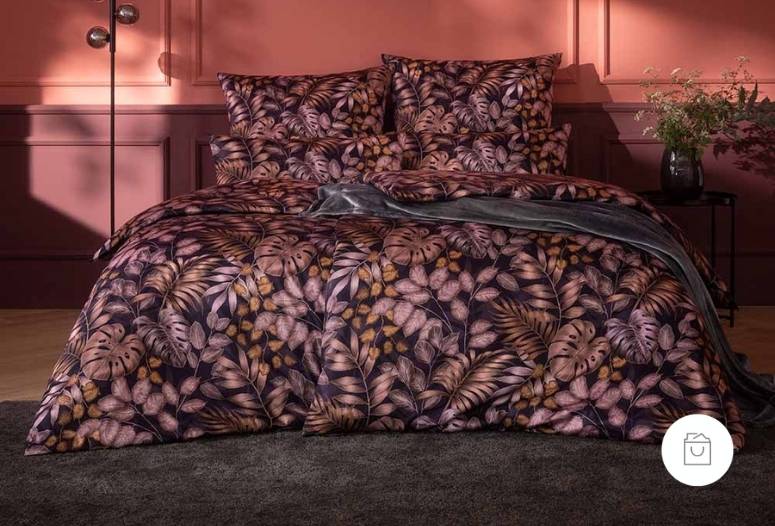 Schweizer Premium Satin Bettwäsche mit zahlreichen Blattmustern in der Farbe Pflaume (tiefer, beeriger Violettton) auf Doppelbett. 
