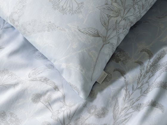 Nahaufnahme des dezenten silbernen Blättermotives auf hellblauen Grund der Bettwäsche Elke