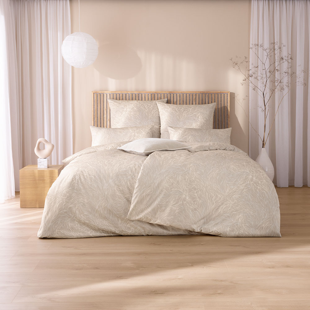 Bettwäsche Sabine mit Blättermuster in Beige und Weiß auf beigem Grund auf Bett im Schlafzimmer