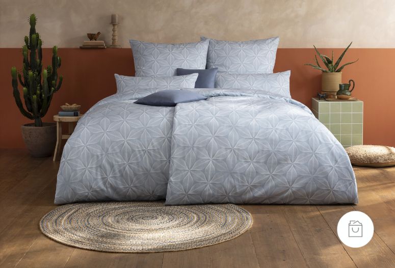 Bettwäsche Lars mit gleichmäßigem geometrischem Muster aus sternförmigen Rauten in kühlen Blau- und Grautönen auf Bett im Schlafzimmer