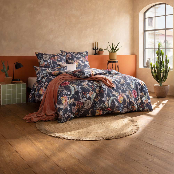 Bettwäsche Claudia mit Blumen in Rosa und Gelb auf dunkelblauem Grund auf Bett im Schlafzimmer