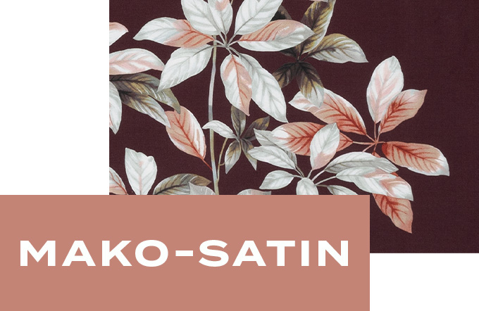 Nahaufnahme des glatten Mako-Satin-Stoffs mit stilisiertem Blättermuster in Rosé, Beige und Weiß auf weinrotem Hintergrund.