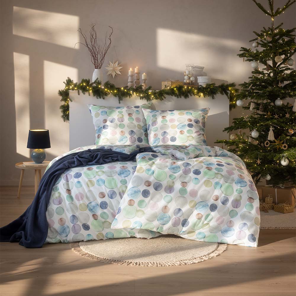 Bettwäsche Colour Dots mit Punktmuster in verschiedenen blassen Farbtönen auf weißem Grund auf Bett im Schlafzimmer