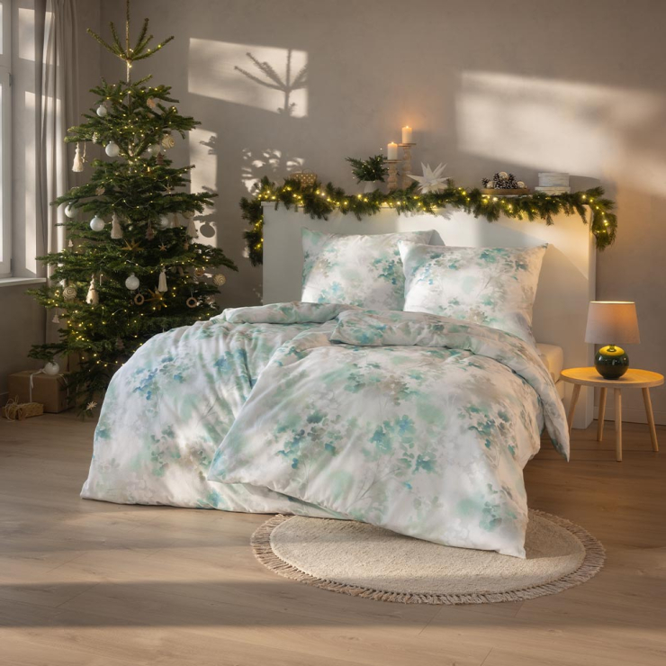 Bettwäsche Frosted Flowers mit floralem Muster in Grün und Weiß auf Bett im Schlafzimmer