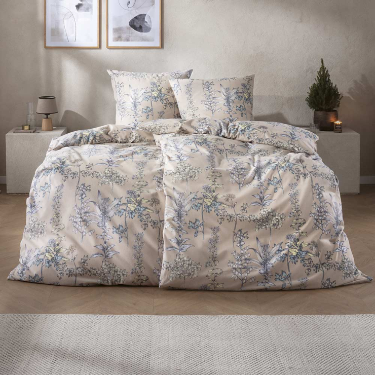 Bettwäsche Appiano mit detailreichen floralen Pflanzenmotiven und feinen Blütenzeichnungen in blassen Blau und Grüntönen auf warmem beigefarbenem Grund auf Bett im Schlafzimmer