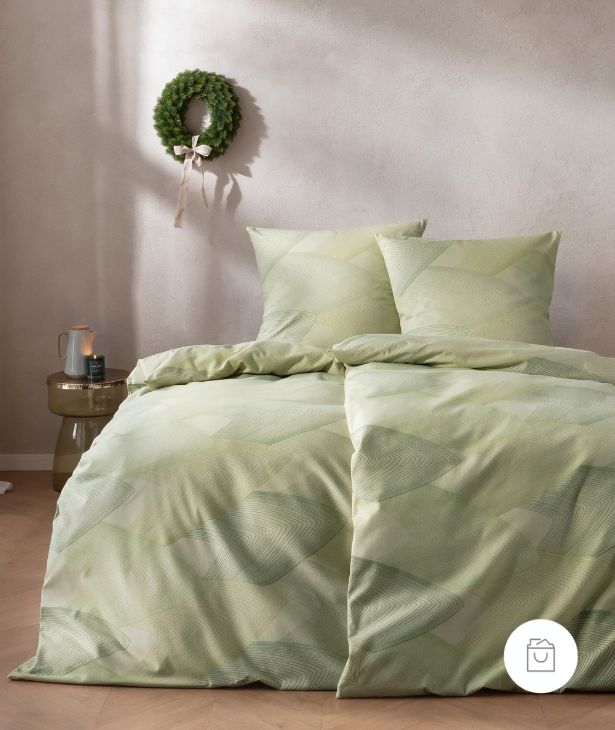 Bettwäsche Bolzano mit überlagernden Rautenformen und feinem Linienverlauf in sanften Grünnuancen auf hellgrünen Grund auf Bett im Schlafzimmer.