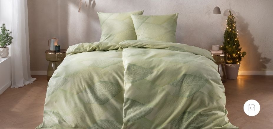 Bettwäsche Bolzano mit überlagernden Rautenformen und feinem Linienverlauf in sanften Grünnuancen auf hellgrünen Grund auf Bett im Schlafzimmer.