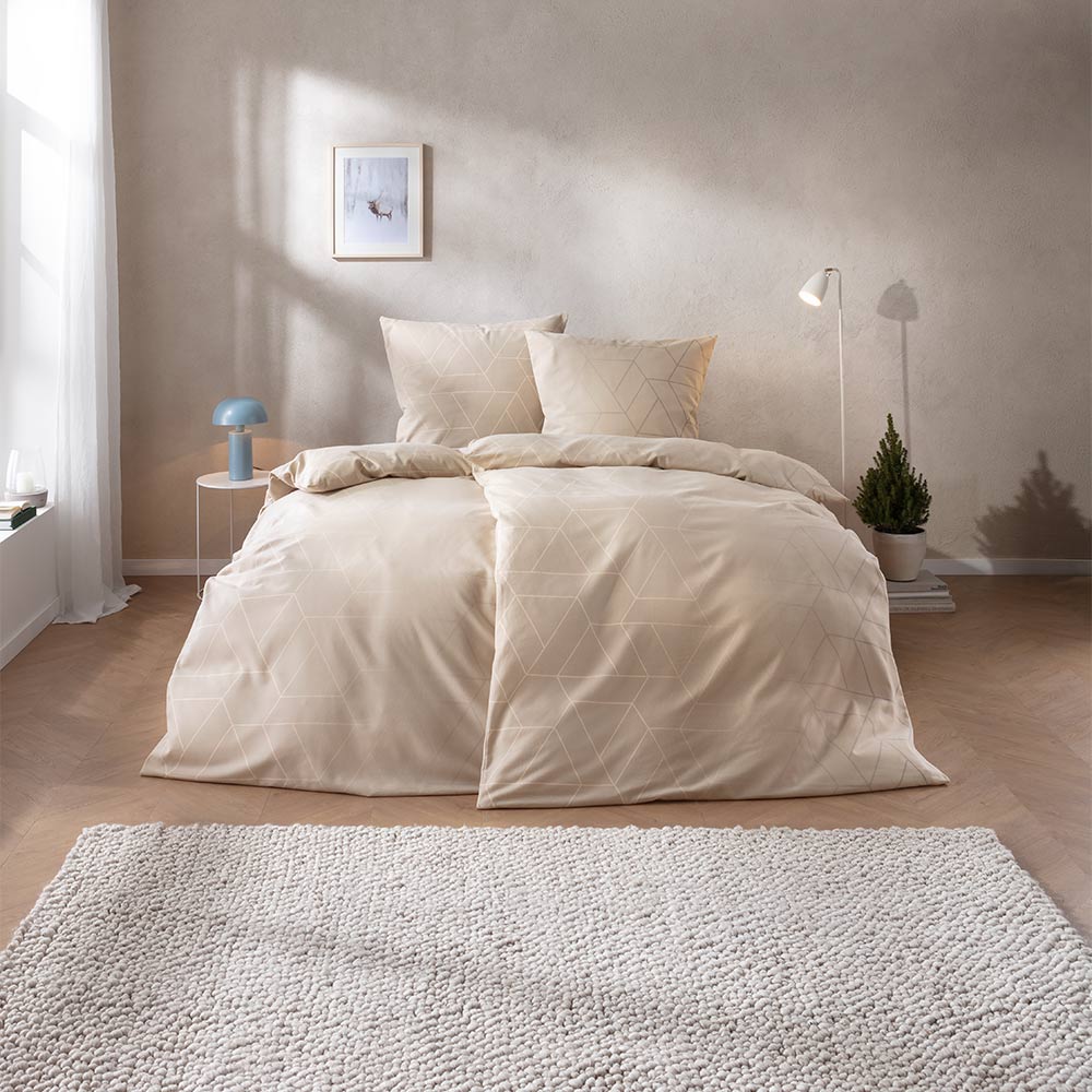 Bettwäsche Andriano mit feinem geometrischem Dreiecken in Creme- und Beigetönen auf hellem Grund auf Bett im Schlafzimmer