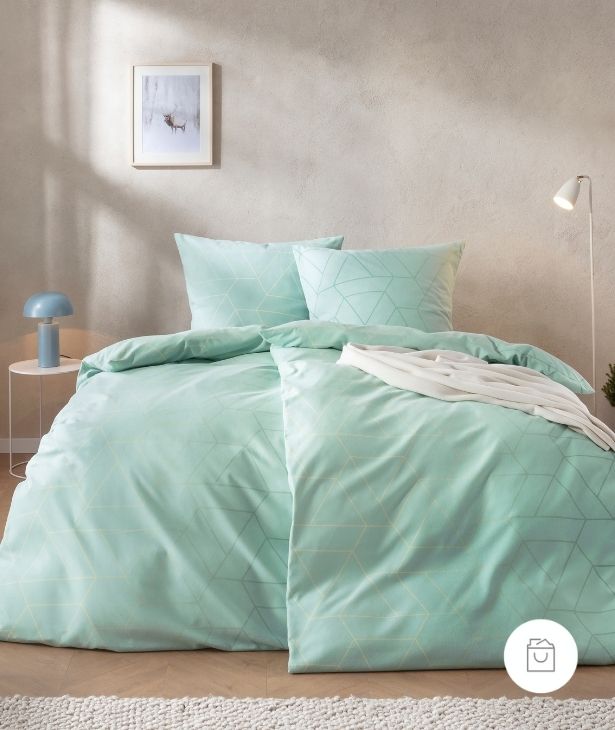 Bettwäsche Andriano mit feinem geometrischem Dreiecken in sanften Mint- und Pastellgrüntönen auf hellem Grund auf Bett im Schlafzimmer