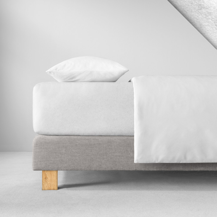 Samtiges Spannbettlaken in weiss aufgezogen auf Bett