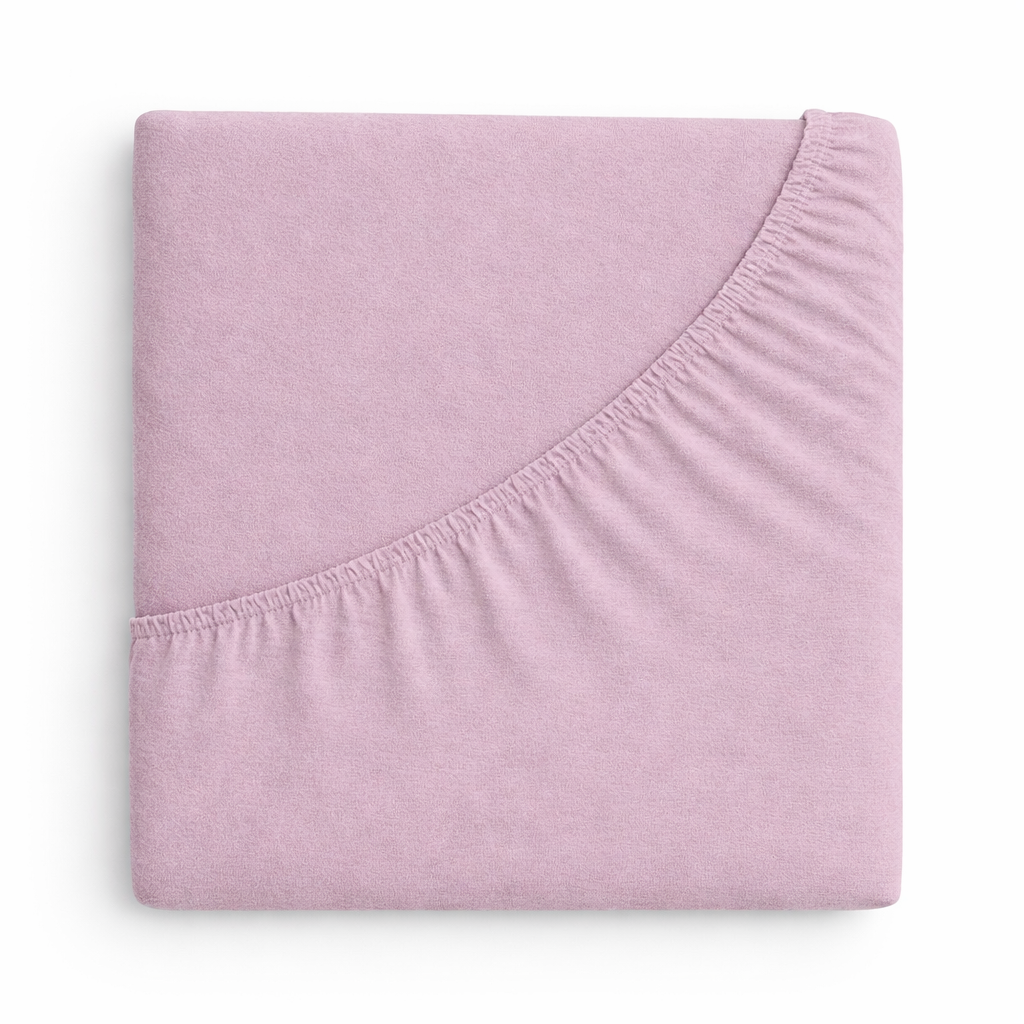 Samtiges Spannbettlaken in einem matten, roséfarbenen Lilaton aufgezogen auf Bett