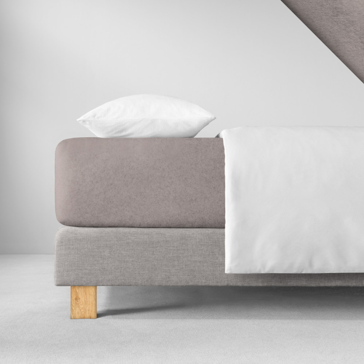 Samtiges Spannbettlaken in einem hellen, warmen Graubraun aufgezogen auf Bett