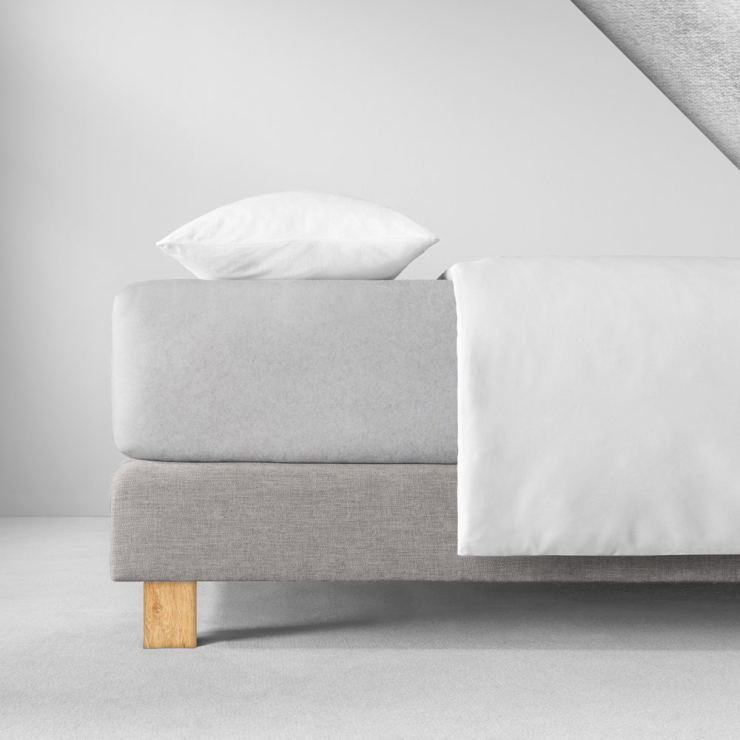 Samtiges Spannbettlaken in einem hellen kühlen Neutralgrau aufgezogen auf Bett