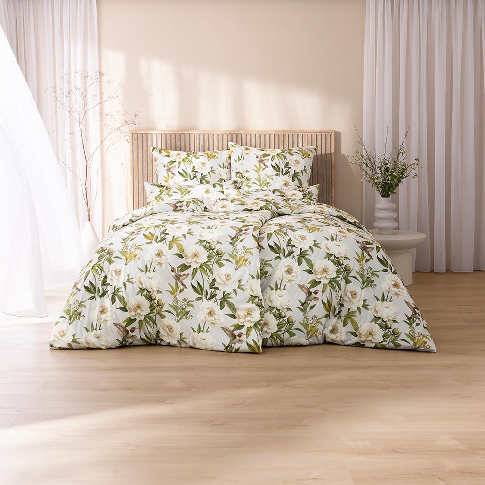 Bettwäsche Yvonne mit Blüten in Weiß und Grün auf weißem Grund auf Bett im Schlafzimmer