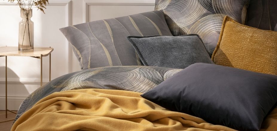 Bettwäsche Toni und Caja gemütlich arrangiert mit der Wohndecke Lana und verschiedenen Dekokissen