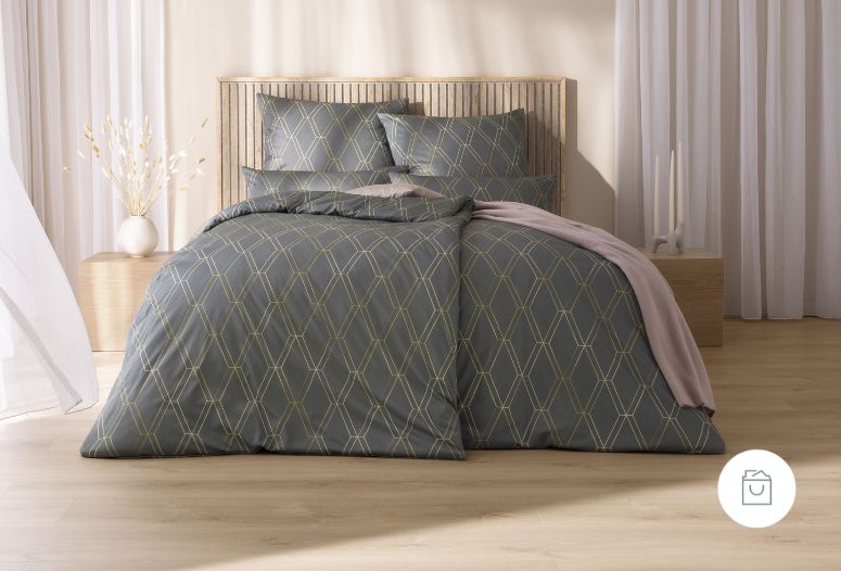 Bettwäsche Robert mit feinem geometrischem Rautenmuster aus goldenen Linien in dunklen Grau- und Goldtönen auf Bett im Schlafzimmer