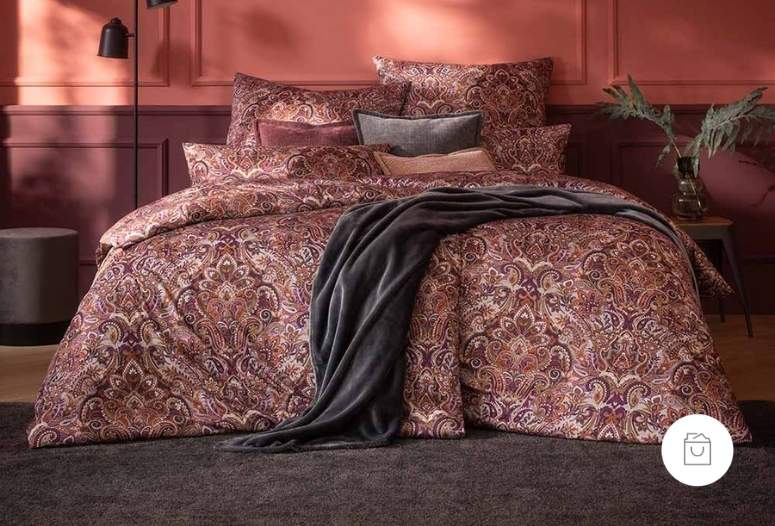 Jersey-Bettwäsche mit detailreichem Paisley-Muster in der Farbe Vino (satter Weinrotton mit warmer Tiefe) auf Doppelbett in stilvoll inszeniertem Schlafzimmer. Demnächst verfügbar.