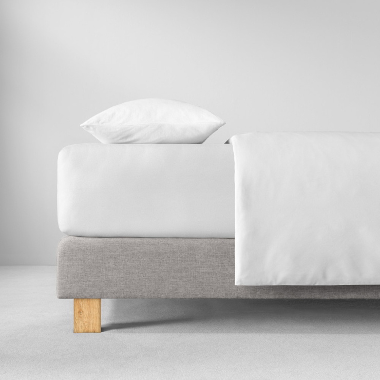 Spannbettlaken in weiss auf Bett aufgezogen