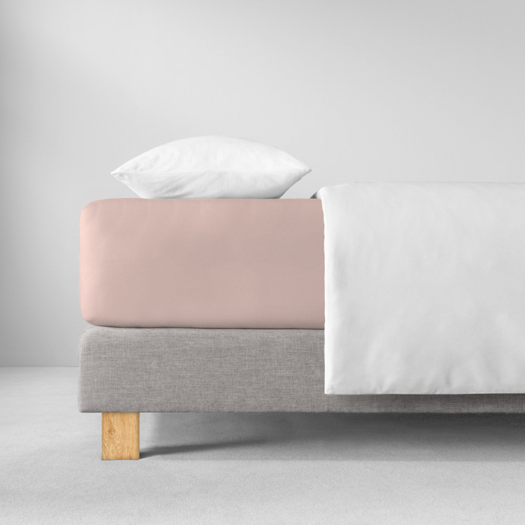 Spannbettlaken in einen rosa (heller, pudrig beiger Rosaton) aufgezogen auf Bett