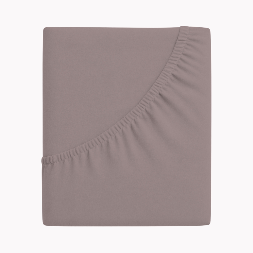 Zwirnjersey Spannbettlaken in einem kieselfarbenen Ton gefaltet dargestellt