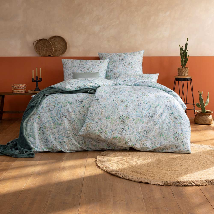 Bettwäsche Nikola mit feinen Paisley-Muster in Grün und Blau auf weißem Grund auf Bett im Schlafzimmer