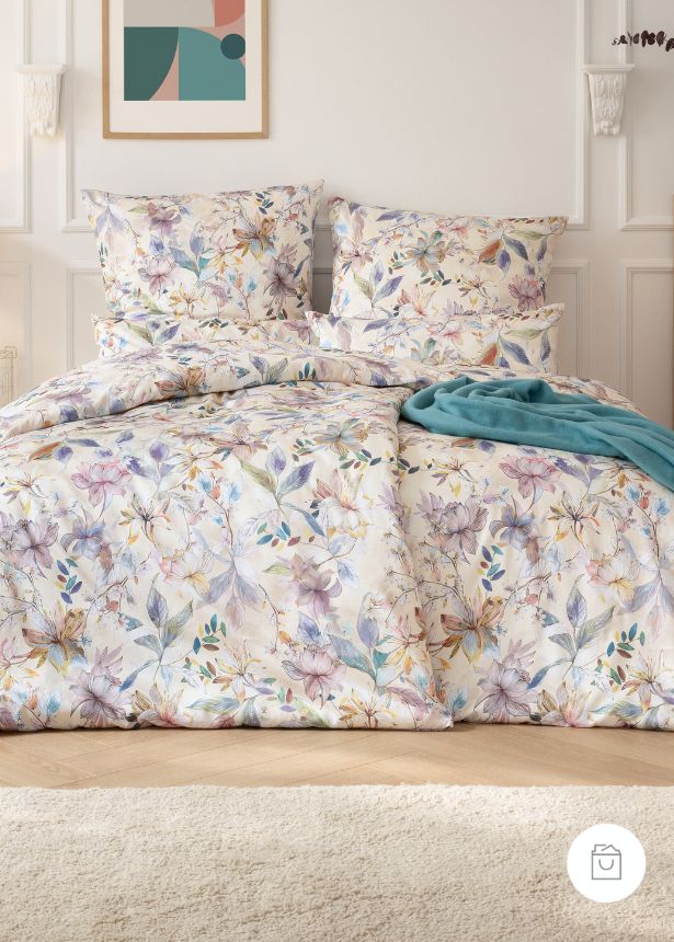 Bettwäsche Estera mit florales Muster in Lila und Grün auf beigem Grund auf Bett im Schlafzimmer