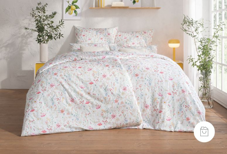 Bettwäsche Celeste mit floralem Muster in Rosa und Grün auf weißem Grund auf Bett im Schlafzimmer