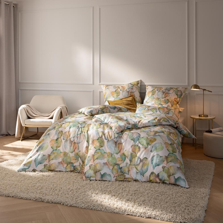 Bettwäsche Theresa mit Blättern in Grün und Beige auf hellem Grund auf Bett im Schlafzimmer