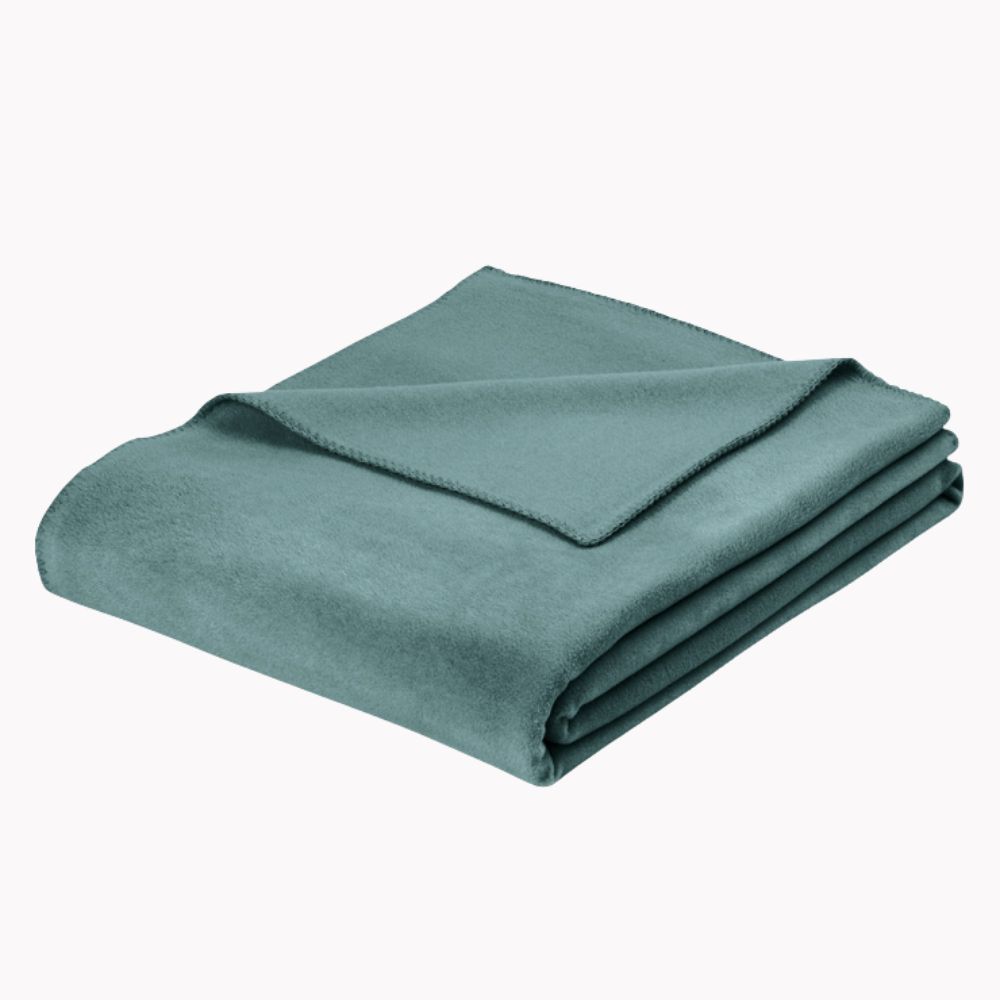 Wohndecke Trevi in gedecktem Grün mit glatter, weicher Oberfläche, gefaltet dargestellt