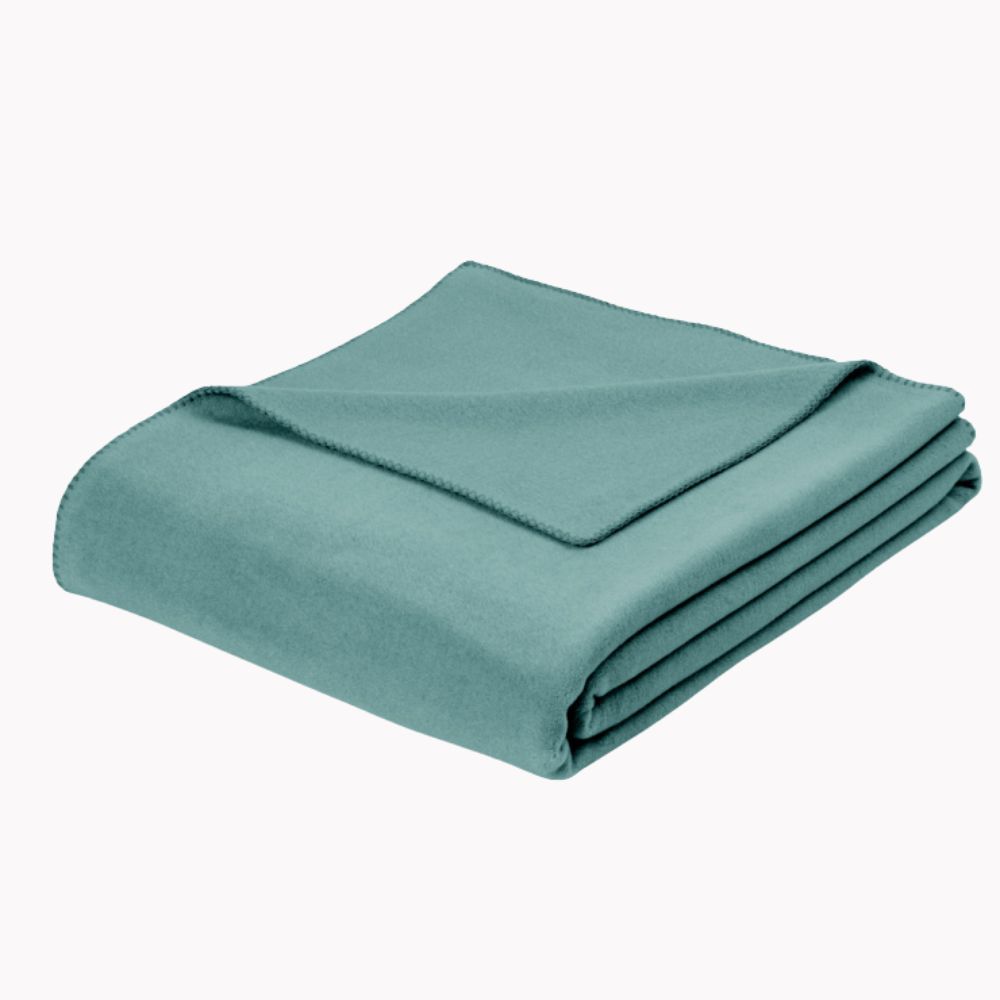 Gefaltete Wohndecke in gedecktem Türkiston (salbeigrün-bläulich) mit feiner Ziernaht