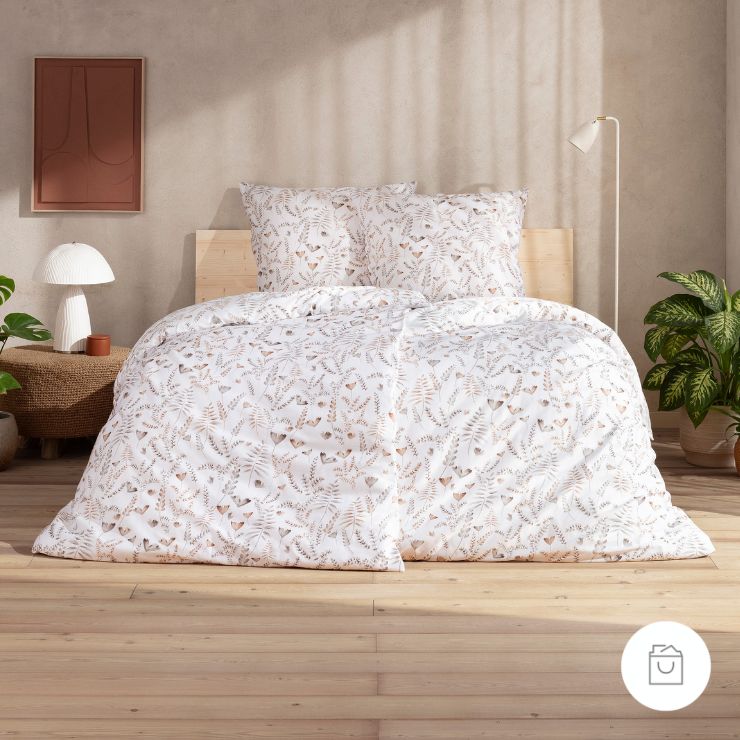 Bettwäsche Alexandra mit Blättermuster in Beige auf weißem Grund auf Bett im Schlafzimmer