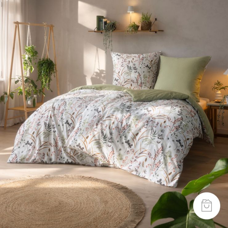 Bio Wendebettwäsche Maria in der Farbe Lind mit zartem Wildgras-Design in warmen Braun-, Rost- und Grüntönen auf weißem Fond, kombiniert mit einer einfarbigen Rückseite in ruhigem Lindgrün.