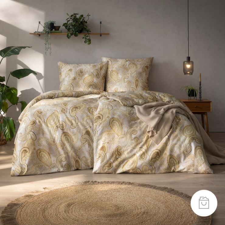 Bio-Bettwäsche Ticiana in der Farbe Altgold mit opulentem Paisley-Muster in Gold- und Cremetönen auf elegant schimmerndem Fond.