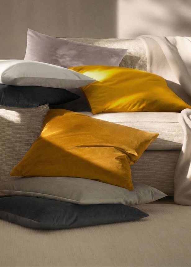Dekokissen Velvet in honig, grau und schiefer auf Sofa und Boden in wohnlicher Umgebung