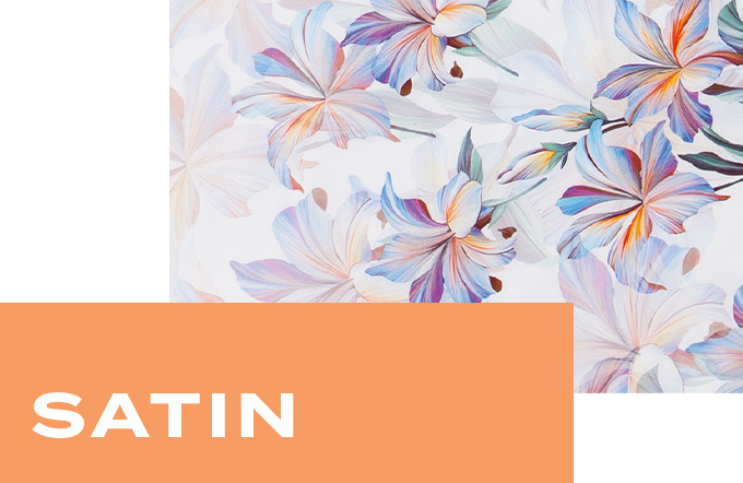 Nahaufnahme des glatten Satin-Stoffs mit floralem Muster in sanften Pastellfarben.