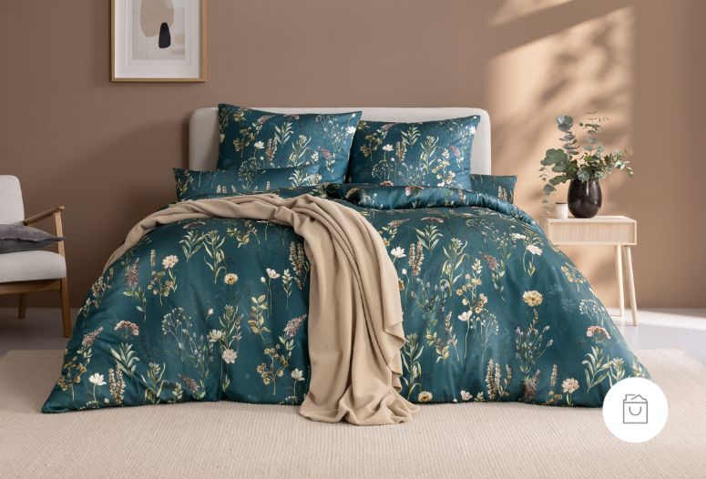 Bettwäsche Evelyn mit Wiesenblumen in Weiß und Rosa auf blauem Grund auf Bett im Schlafzimmer