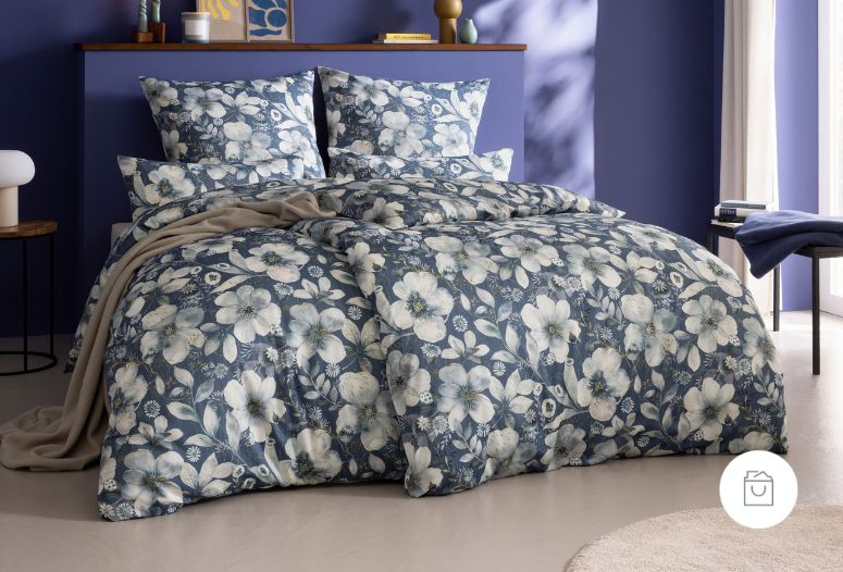 Bettwäsche Ilona mit Blüten in Weiß und Hellblau auf blauem Grund auf Bett im Schlafzimmer