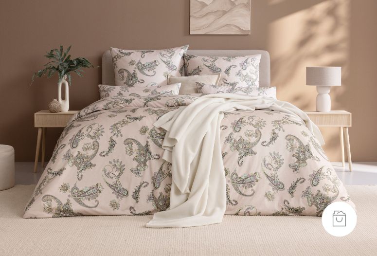 Bettwäsche Katrin mit Paisleymuster in Grün und Beige auf hellrosa Grund auf Bett im Schlafzimmer