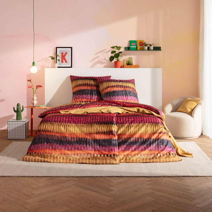 Bettwäsche Dawn mit geometrischem Muster in Rot und Orange auf Bett im Schlafzimmer